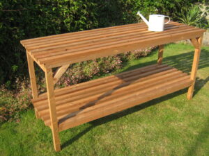 Two-tier wooden greenhouse staging on a garden lawn beside trimmed hedges - Greenhouse Staging